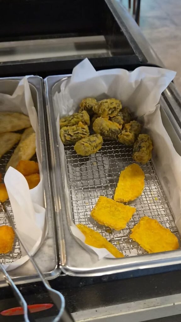 A tray of fried snacks at Dookki including sweet potato tempura, seaweed rolls and vegetable fritters