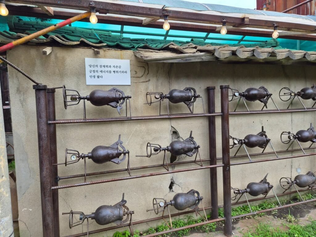 Rows of original textile machinery mounted along a wall at Jogyang Bangjik, a 1930s mill turned cafe on Ganghwa Island
