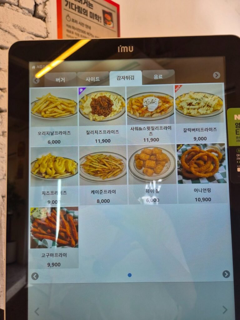 Touchscreen ordering kiosk at Masian 300 showing a photograph and price for each side dish