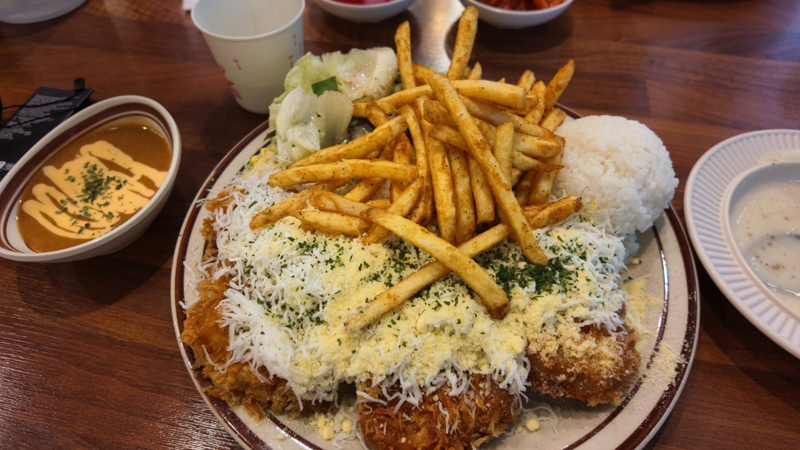 Snow cheese pork cutlet with fries, rice and salad on one plate
