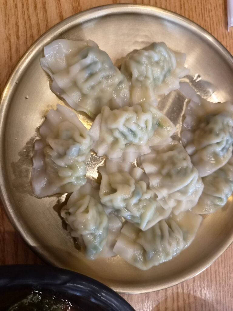 A brass plate of water dumplings served free with the meal at Unseook