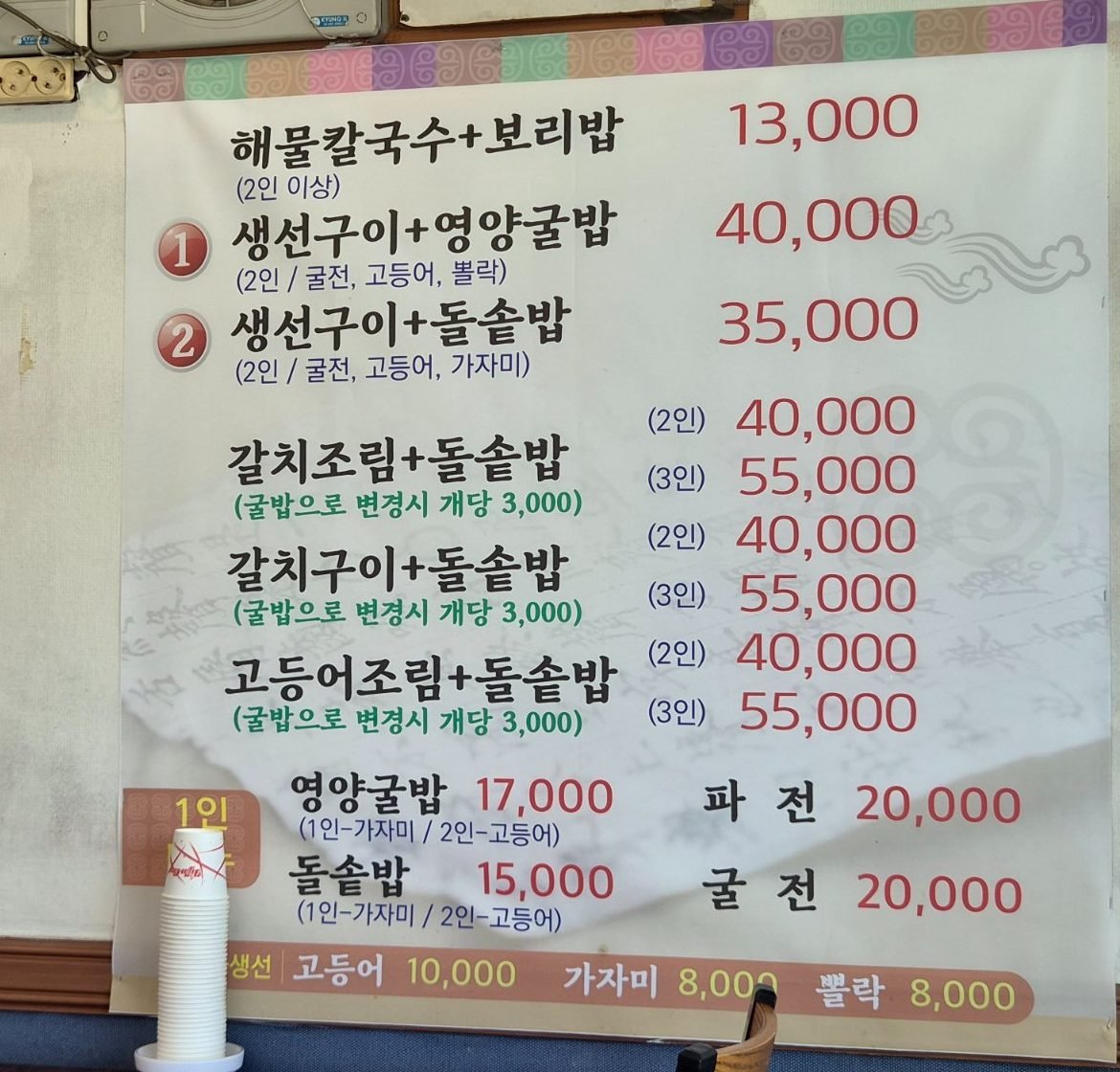 Wall menu board at Irionora listing grilled fish sets at 40,000 and 35,000 won and single stone pot rice at 15,000 won