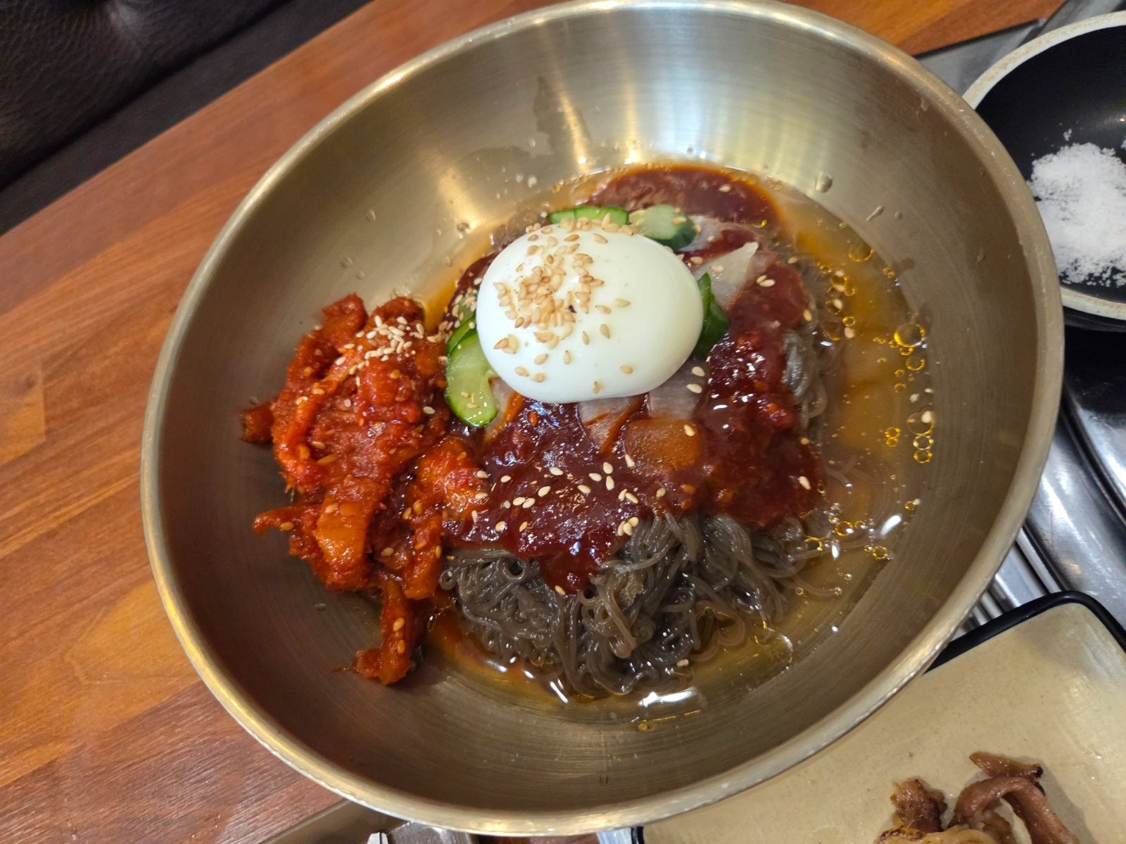 Myeongtae-hoe naengmyeon, cold noodles topped with spicy pollack, cucumber and half a boiled egg