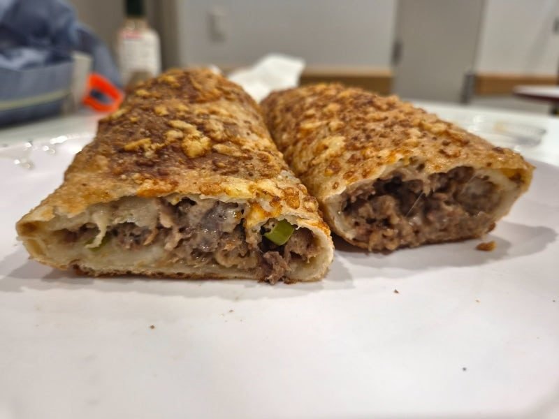 Two cut halves of a bake showing the beef and cheese filling