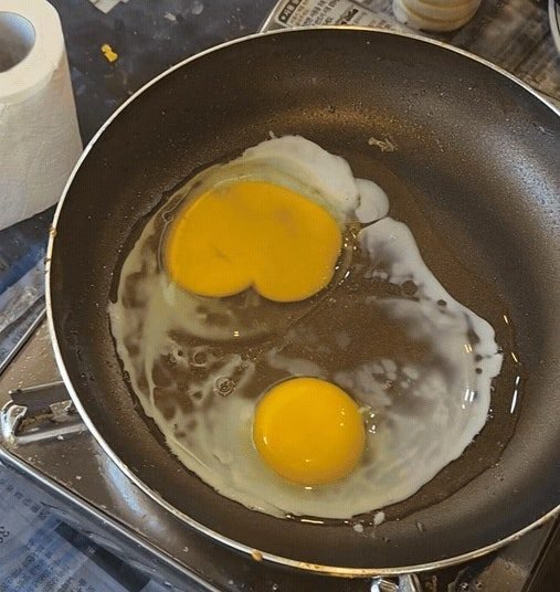Two eggs frying in a shallow pan on the self-serve egg burner at Hongsil.