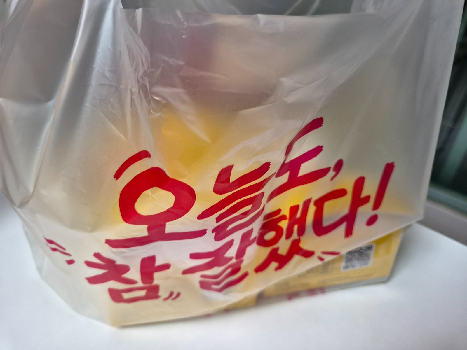 Yellow plastic takeout bag printed with the Korean phrase oneuldo cham jalhaetda