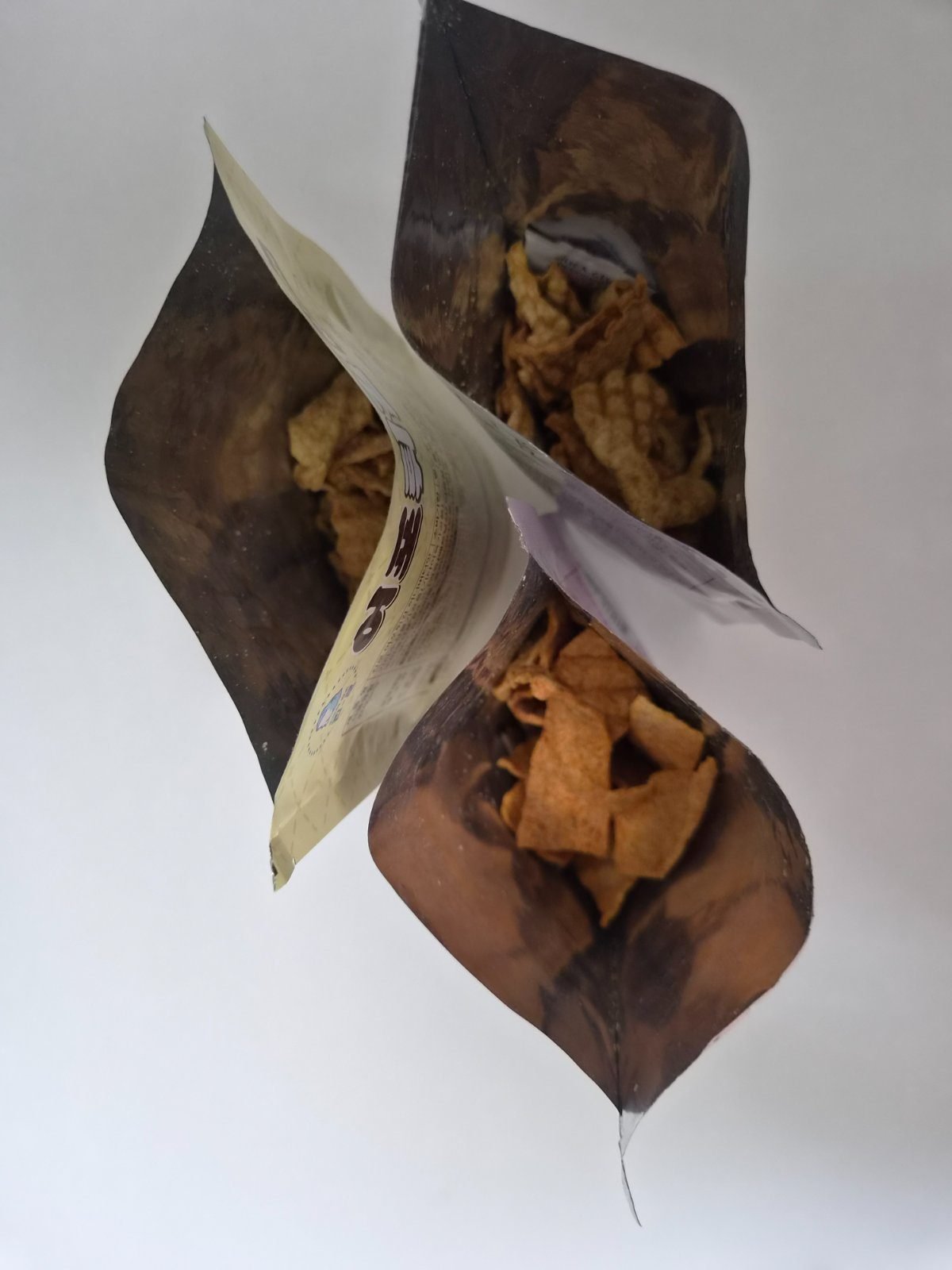An opened bag of Korean fried fish crisps showing thin golden-brown pieces