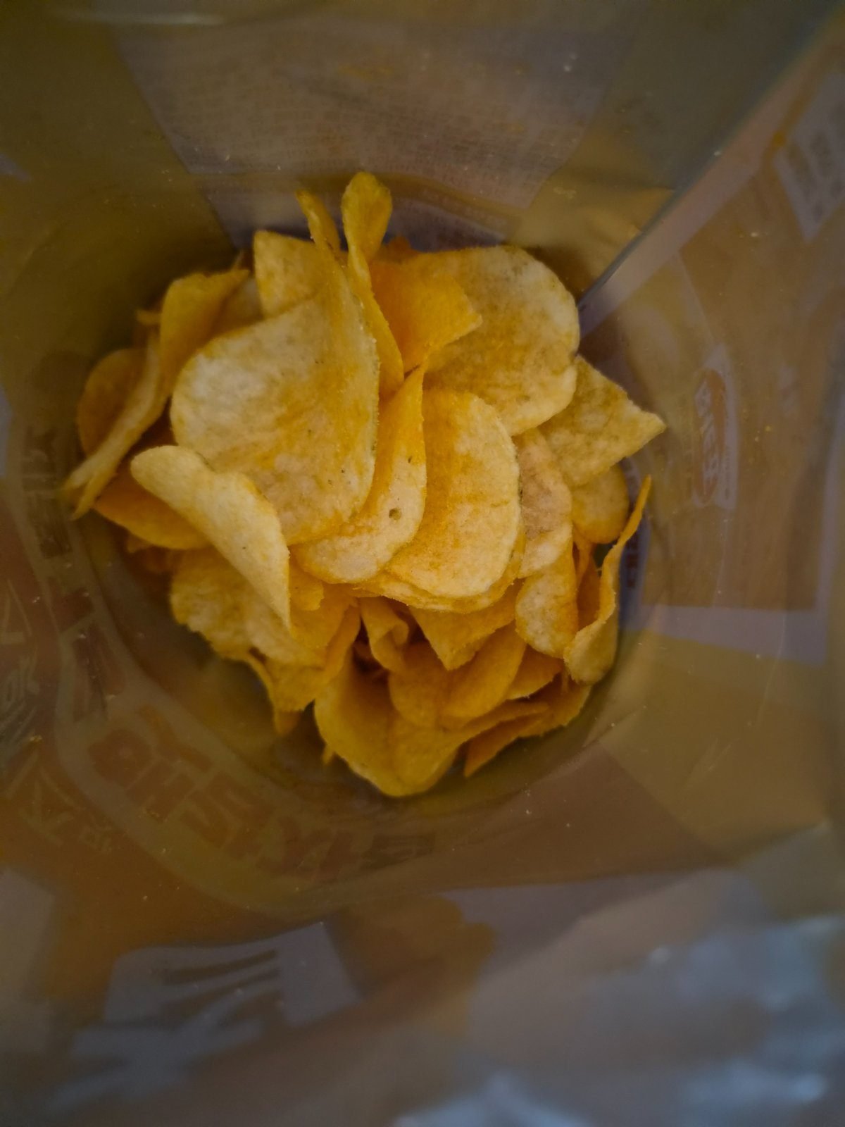Thin ridged potato chips inside an opened Pocachip Sweet Cheese bag