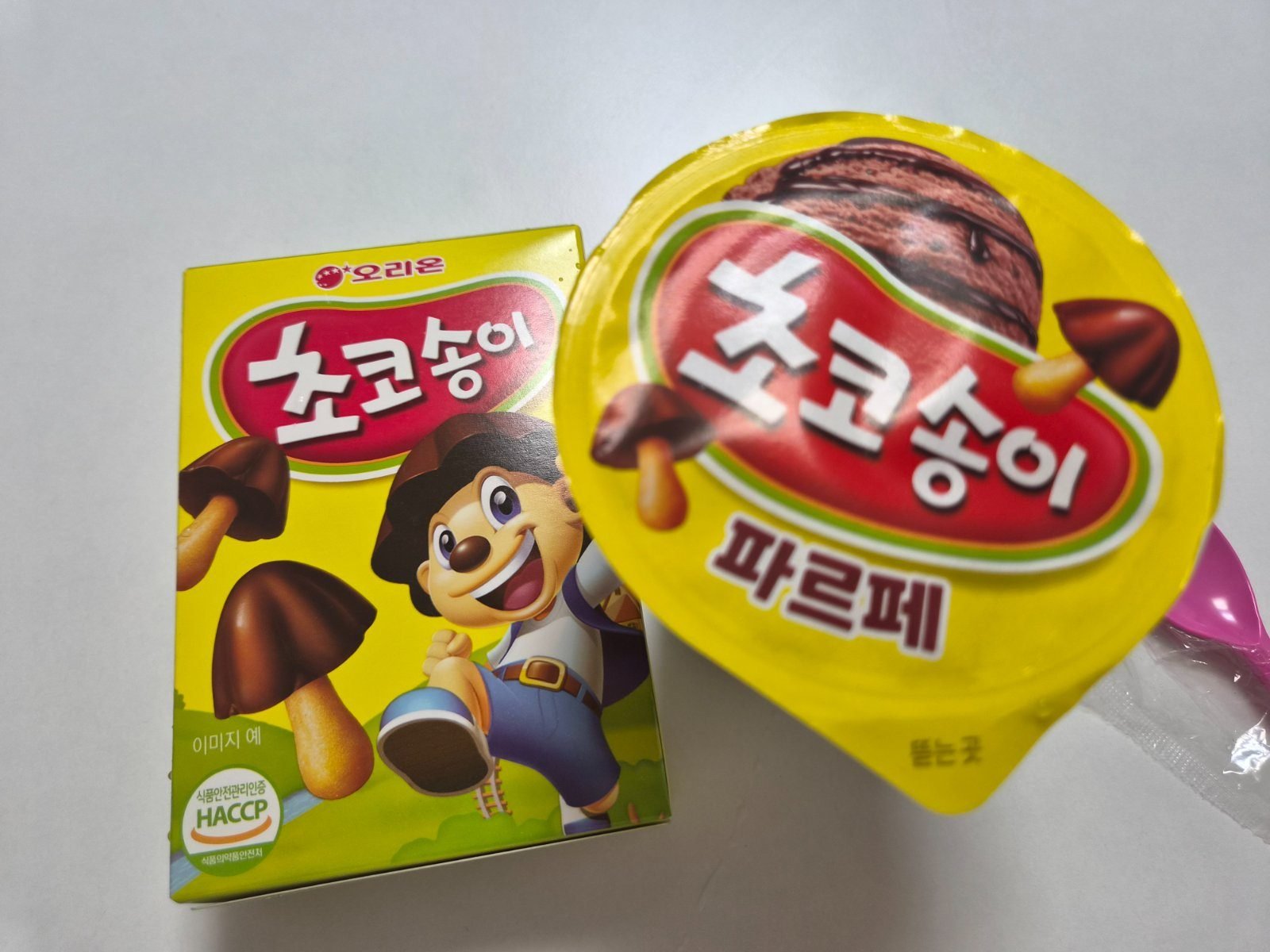 A Choco Songi cookie box next to the yellow lid of the Choco Songi parfait ice cream cup